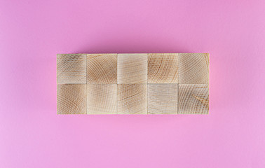 flatlay with ten blank wooden cubes arranged on pink background, template to add text
