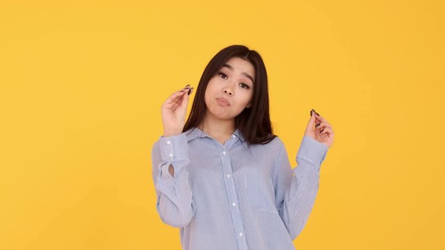girl Asian yellow background showse gesture bla bla. girl doesn't want talk
