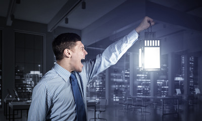 Fototapeta premium Screaming businessman holding glowing lantern