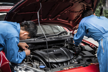 Fototapeta na wymiar Two auto mechanic doing car service and maintenance.