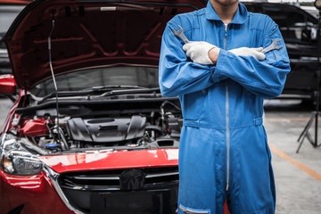 Arms crossed of auto mechanic doing car service and maintenance.