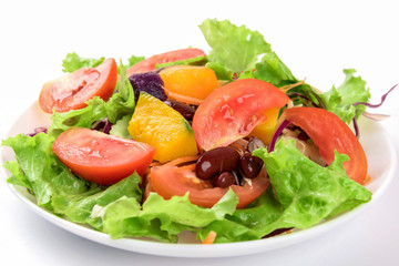 Fresh vegetable salad on plate over white background.