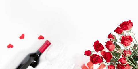 Fototapeta na wymiar Red roses, flowers bouquet, gift, wine and glasses for wine on white background. Women's Day, Valentine's Day, Birthday. Flat lay, top view, copy space