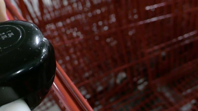 inserting coin in coin lock, taking shopping cart