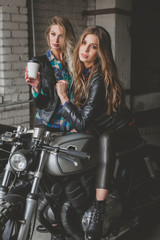 Obraz na płótnie Canvas Sexy biker girls sitting on vintage custom motorcycles