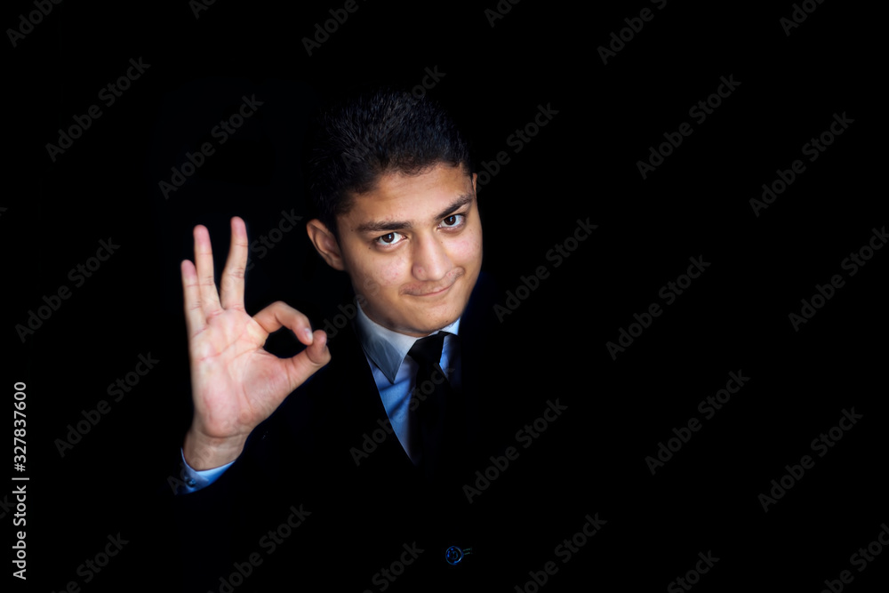 Wall mural portrait shot of smiling happy businessman agreeing or accepting with an ok hand gesture and positiv