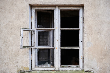 Fototapeta na wymiar Broken window in old wall of abandoned house