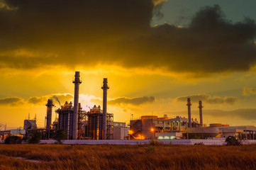 Fototapeta na wymiar Natural gas combine cycle power plant and turbine generator in dusk with orange sky