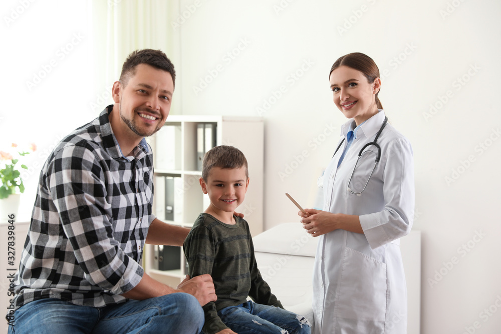 Wall mural Father and son visiting pediatrician. Doctor working with patient in hospital