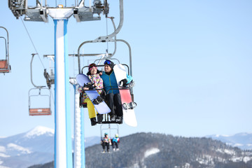 Fototapeta na wymiar People using chairlift at mountain ski resort. Winter vacation
