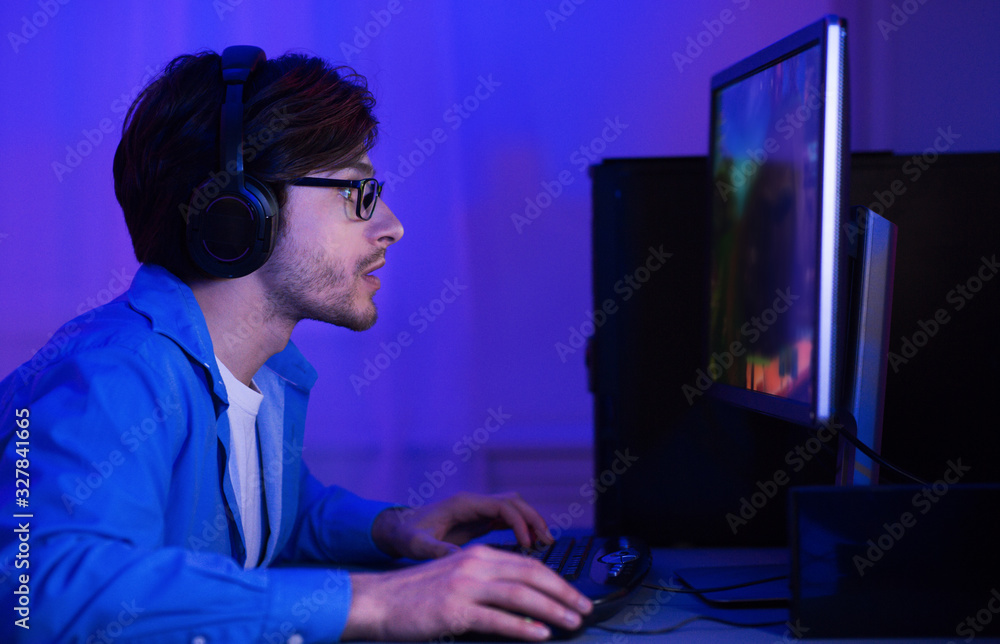 Poster gamer taking part in online tournamet sitting at computer indoor