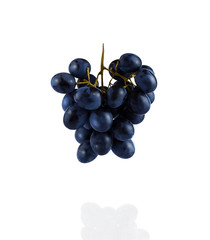 A bunch of grapes hanging in the air, isolated on a white background. Falling, flying food. Close up.