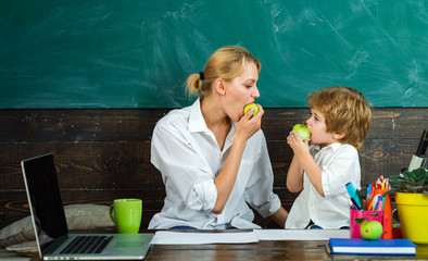 Family time. Mom and son eating an apple. Healthy snack at school.