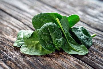 fresh spinach leaves on wooden board