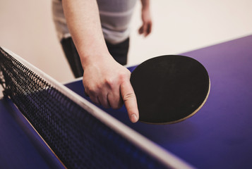ping pong player holds a table tennis racket in his hand