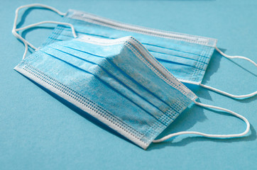 Blue protective medical masks lie on a blue background