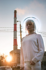 Albino girl in a spacesuit against the background of plants and smoke.