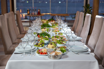 Salads and gums . Set of a dish with spoon, fork and knife on white table.Table setting on white table .