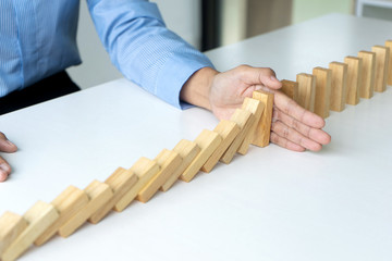 young business people use the hand to Stop wooden brick