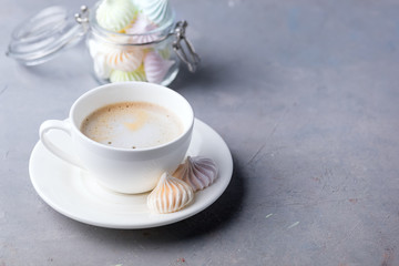 Small Meringues in Glass Jar and Cup of Coffee on Gray Background Tasty Dessert for Coffee or Tea Gift for Holidays Horizontal Copy Space