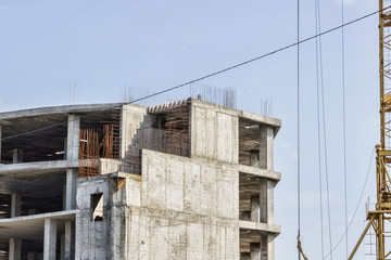 Construction of the building. Hoisting crane on blue sky background.