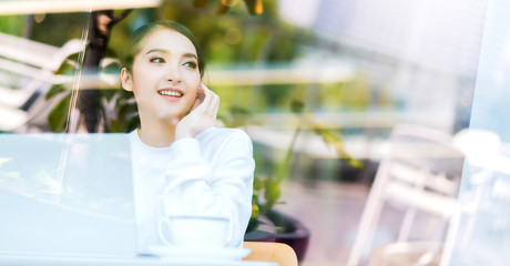 Fototapeta na wymiar entrepreneur startup business owner attractive asian female business woman communication with smartphone and laptop white dress cheerful and smile with confience blur office background