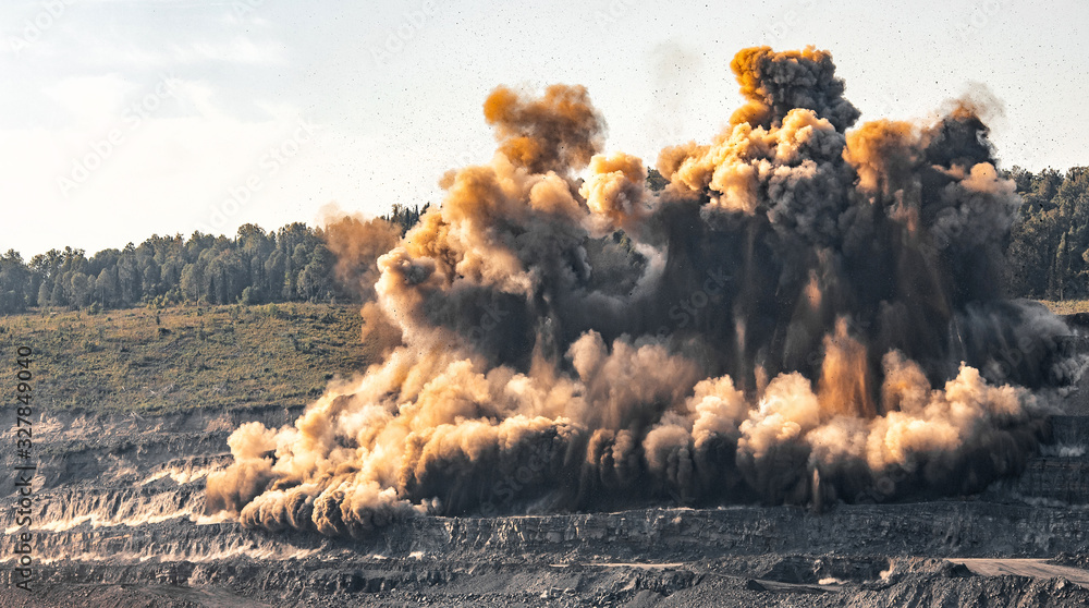Wall mural Explosive works on open pit coal mine industry. Dust and puffs of smoke in sky, blasted soil - Wall murals