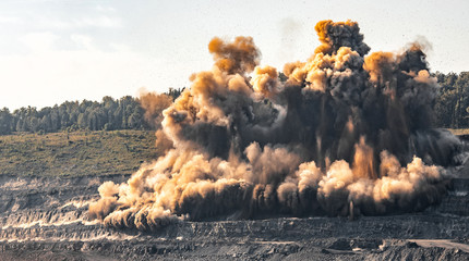Explosive works on open pit coal mine industry. Dust and puffs of smoke in sky, blasted soil © Parilov