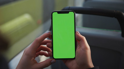 Lviv, Ukraine - May 19, 2018: Hands use touch holding a mobile telephone with a vertical green screen in tram chroma key smartphone technology cell phone street touch message display hand