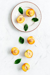 Peaches pattern with plate and leaves on white table top-down