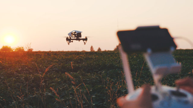 Close up hands farmer controls smart agriculture drone flying in sky rural aerial helicopter agros copter farm field industry landscape meadow nature plant vehicle harvest innovation slow motion