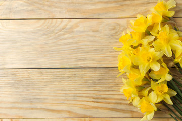 Spring flowers, frame of yellow daffodils on a natural wooden background. place for text