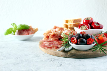 Antipasto: ham, olives, salami, tomato, pepper and bread. Top view with copy space.
