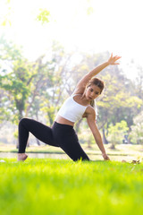 Portrait of young woman practicing yoga in garden.female happiness. blurred background.Healthy lifestyle and relaxation concept.Young Asian Girl doing yoga in the park