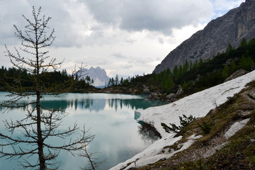 Fototapeta na wymiar Lago di Sorapiss lake at summer after rain. Amazing mountains landscape. Blue water in mountains lake 