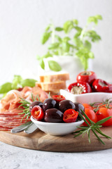 Antipasto: ham, olives, salami, tomato, pepper and bread. Top view with copy space.