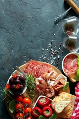 Antipasto - olives, ham, salami, tomato, pepper and bread. Top view with copy space.