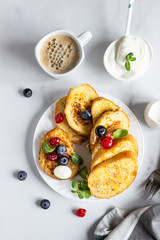 Traditional sweet French toasts with blueberry, dried cherry, mint and coffee. Delicious breakfast. Top view.