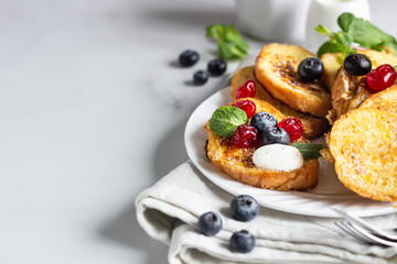 Traditional sweet French toasts with blueberry, dried cherry, mint and coffee. Delicious breakfast. 