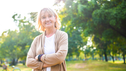 portrait of happy Caucasian beautiful elderly woman smile at park, Retired older female relaxing outdoor in sunny day, Positive thinking and healthy lifestyle insurance concept, copy space