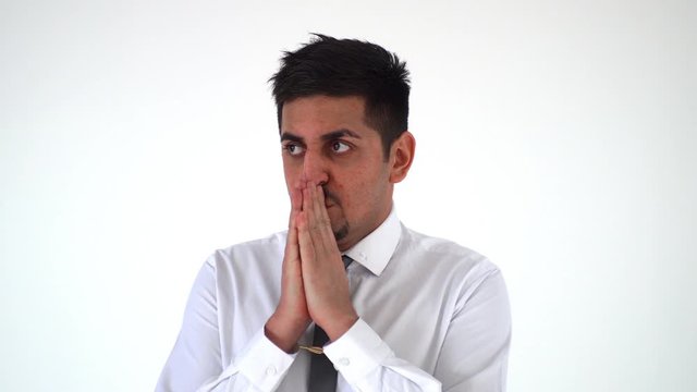 the man holds his folded hands to his face. A businessman experiencing a problem