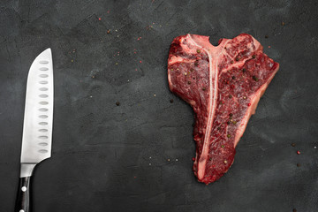 T-bone or Porterhouse and knife on a black background. 