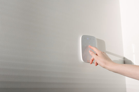 Home security concept. Woman hand entering a home security code