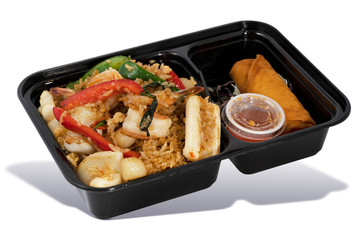 Seafood Thai Basil Fried Rice with Spring Roll and Sweet Sauce in Takeaway Box on White Background. Asian Food. Delivery Food. Clipping Path on the main object (not the shadow) Included.
