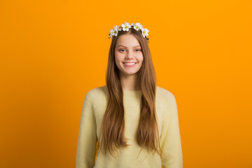 beautiful young woman with a wreath on her head on a yellow background