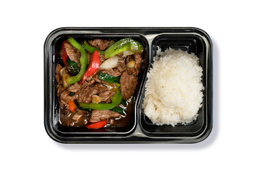 Top View of Beef sautéed with bell pepper, and oyster sauce with Steamed Jasmine Rice in Takeaway Box on White Background. Asian Food. Delivery Food. Clipping Path on the main object (not the shadow)