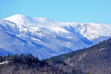 View of blowing snow atop Mount Washington with Cathederal ledge in the foreground