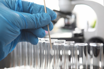 Scientist wearing protective gloves examining dna samples