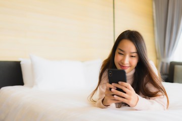 Portrait beautiful young asian woman with coffee cup and mobile phone on bed