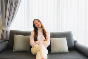Fototapeta premium Portrait beautiful young asian woman sit on sofa chair for relax in living room